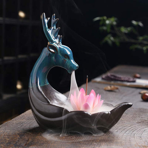 Little Deer Ceramic Lotus Incense Burner – Iridescent teal deer with pink lotus, cascading smoke on wood, backflow incense Imagen principal del producto