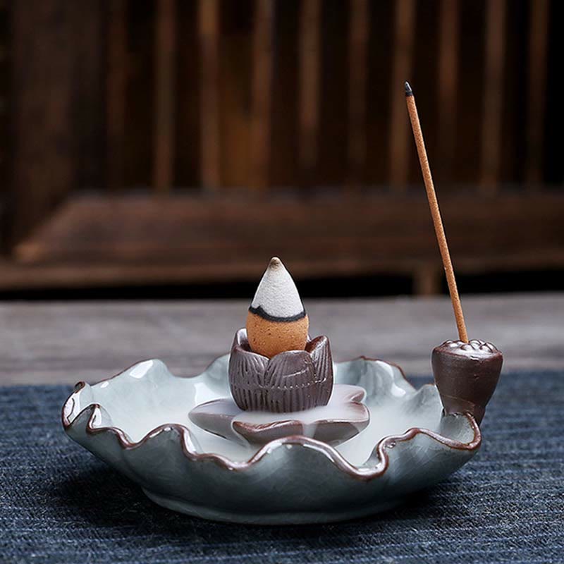 Lotus Ceramic Backflow Incense Burner - complete lotus dish with incense loaded on navy fabric, zen setting