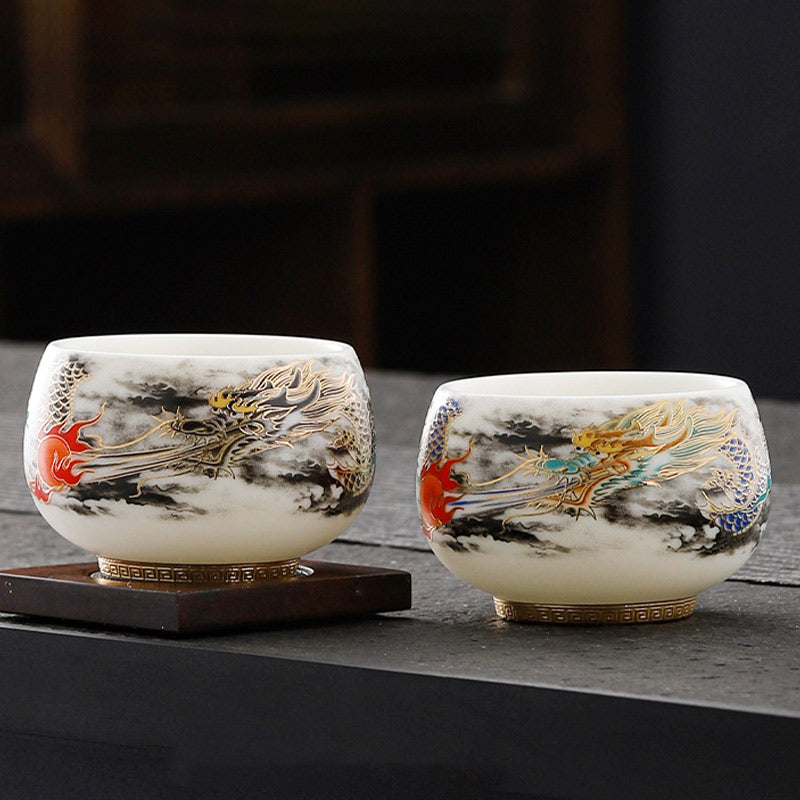 Dragon Playing Pearl Porcelain Teacup – Paired dragon cups with gold turquoise on dark stone, lifestyle warm wood