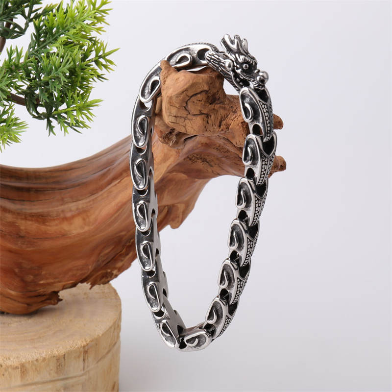 Dragon Titanium Steel Luck Bracelet Bangle - dragon head gripping pearl on wood with greenery, antique silver finish