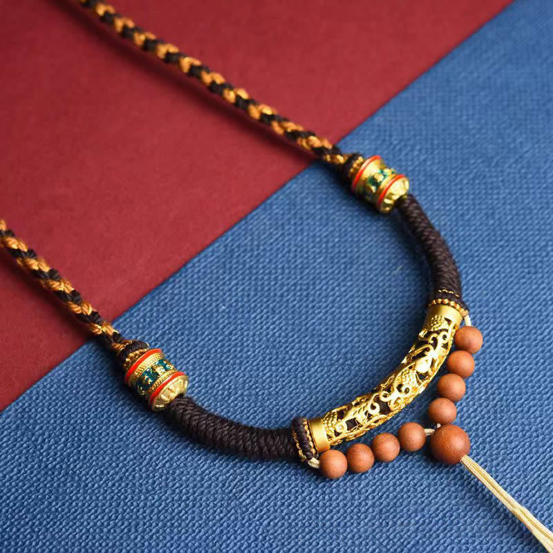 Tibetan King Kong Knot Prayer Wheel Necklace – macro view of carved gold charm with enamel inlay, artisan craft