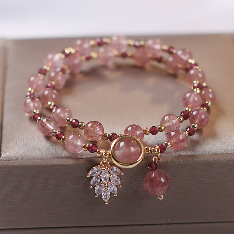 Double-wrap strawberry quartz bracelet with alternating pink beads and burgundy garnet accents gold tone findings leaf crystal spray and teardrop dangle charm