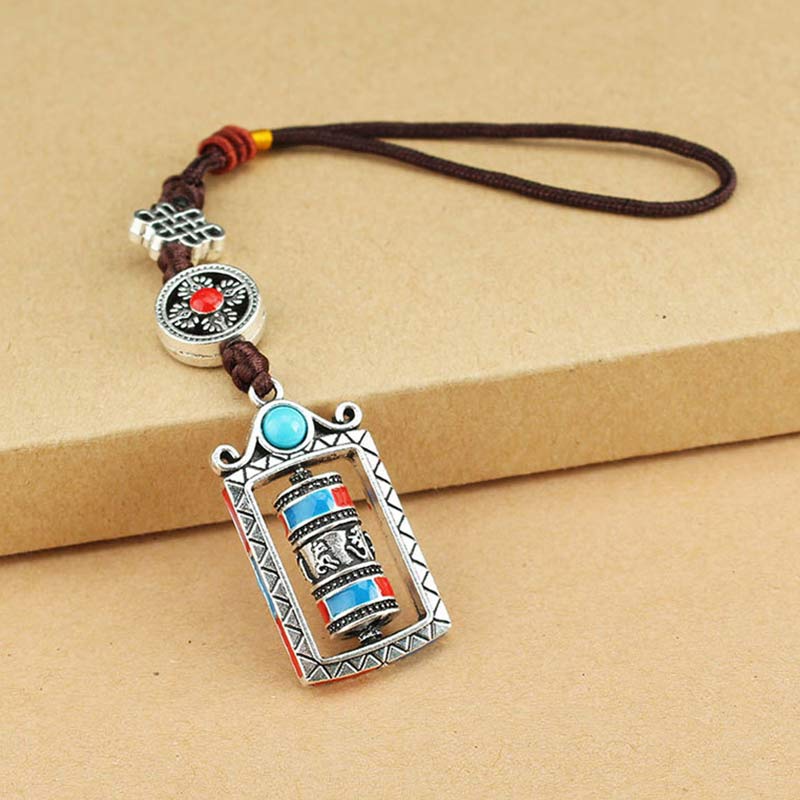 Om Mani Padme Hum Prayer Wheel Keychain – Flat lay on kraft cardboard, full charm detail visible, Buddhist keychain