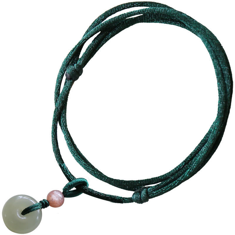 Jade Peace Buckle Lotus Necklace – Clean white backdrop shot of jade bi-disc with pink bead on green cord, jade pendant