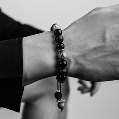 Black Obsidian Lava Rock Bracelet – Wrist shot showing beaded bracelet with gold spacers, adjustable cord
