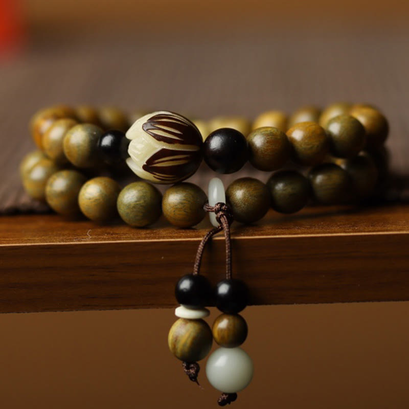 Green Sandalwood Lotus Bracelet – macro of carved lotus bead on wood, tassel with onyx drops