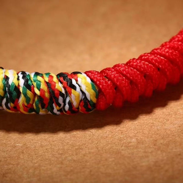 Tibetan Mantra Bracelet – Five-color braided section joining solid red cord, macro knot texture detail