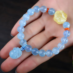 Aquamarine PiXiu Bracelet – Close-up on hand showing blue beads, PiXiu detail, red spacers, calming accessory