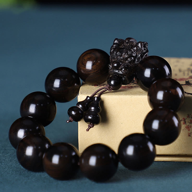 Multi-Wood Dragon Bracelet - Dark ebony beads with dragon head and gourd pendants on gold box, Strength