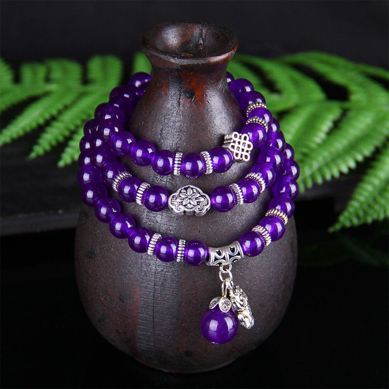 Amethyst PiXiu Bracelet – Amethyst bracelet draped on ceramic vase with green fern