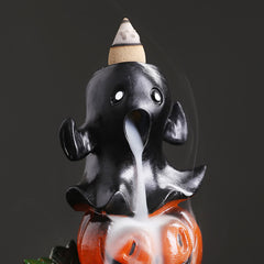 Black elephant backflow incense burner on orange pumpkin base, smoke pouring from trunk, white eyes, dark background – Halloween incense holder