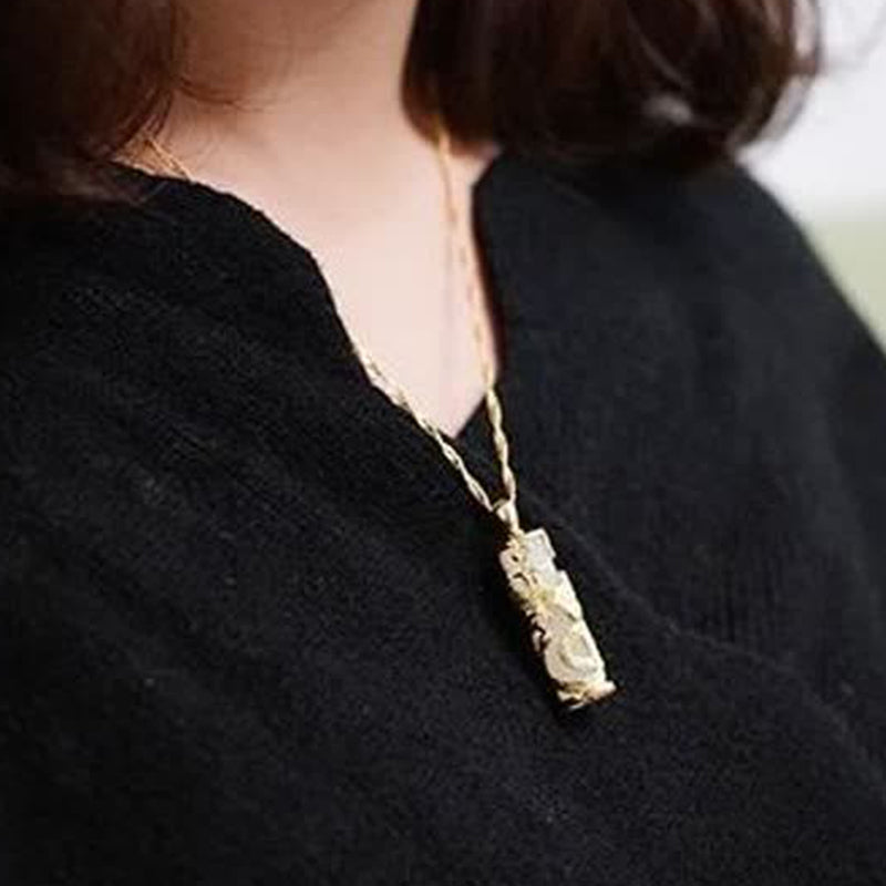 Jade Dragon Phoenix Copper Pendant – Textured gold pendant worn on model with black knit top, artisanal