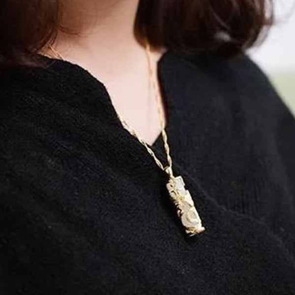 Jade Dragon Phoenix Copper Pendant – Textured gold pendant worn on model with black knit top, artisanal