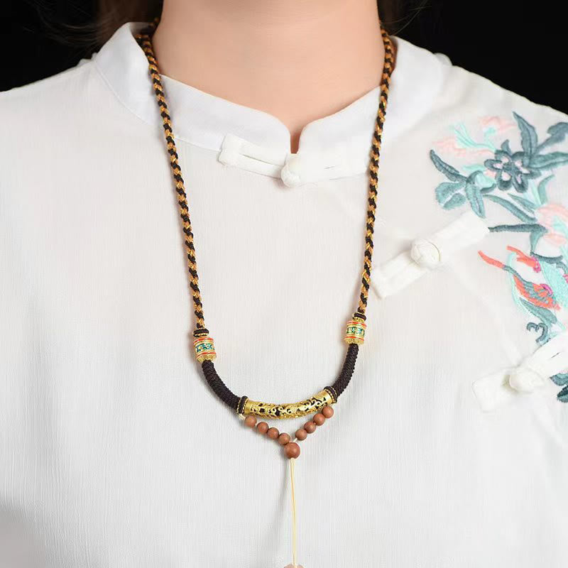 Tibetan King Kong Knot Prayer Wheel Necklace – worn on model in white traditional blouse, mantra necklace