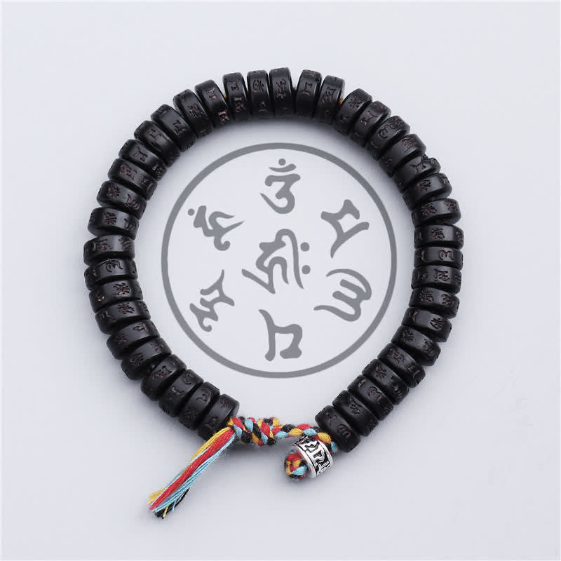 Coconut Shell Mantra Bracelet - Top-down circular view of carved mantra discs, five-color Buddhist tassel