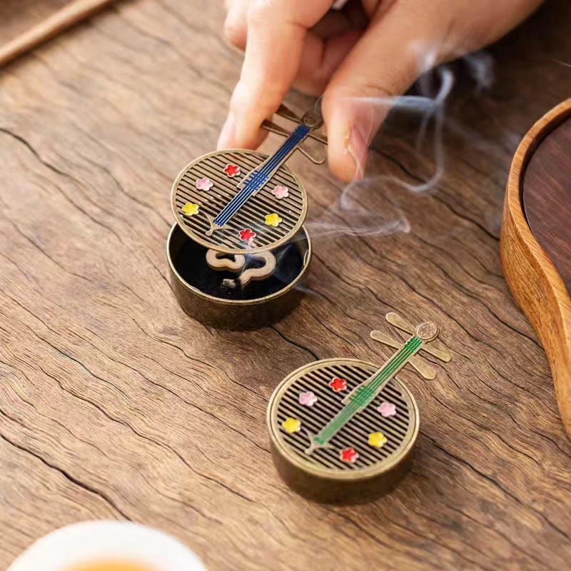 Copper Incense Burner Set – pipa burners in blue and green, hand lifting lid, smoke curling up