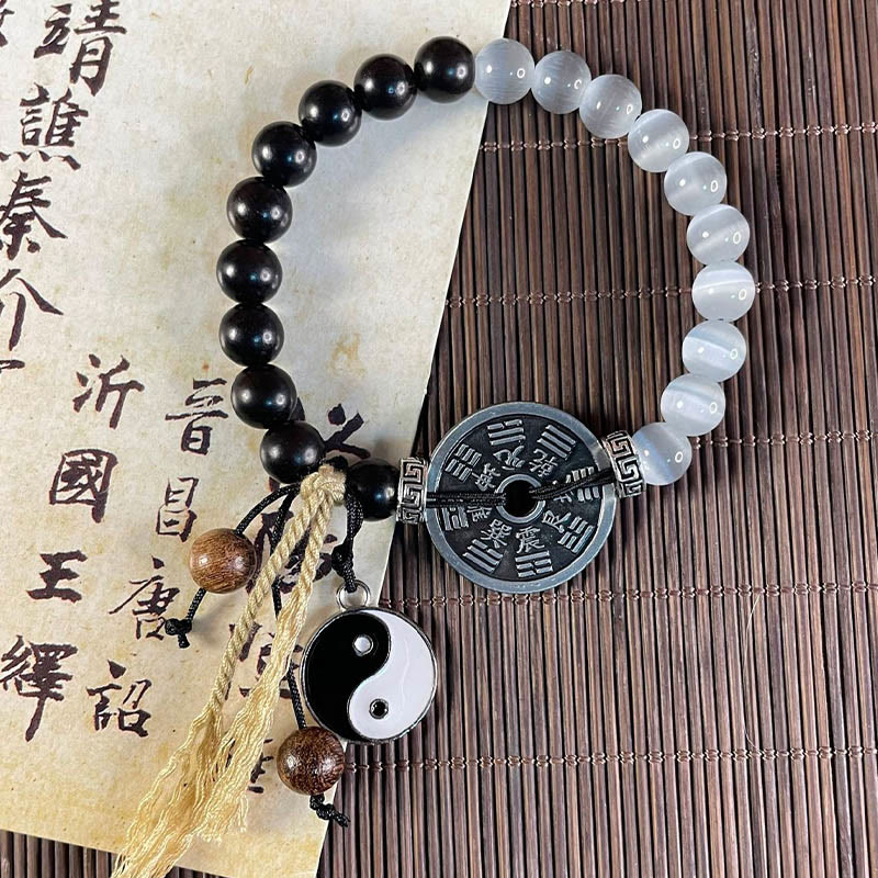 Cat's Eye Ebony Wood Yin Yang Bagua Coin Bracelet – Beaded bracelet with Bagua coin on calligraphy scroll, flat lay