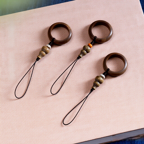 Sandalwood Phone Grip – Three assorted sandalwood ring lanyards flat lay on textured fabric, multi-style phone grip set