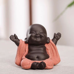 Laughing Buddha Purple Clay Maitreya Statue – two-tone ceramic seated Buddha with arms raised, dark brown skin and speckled coral robe, zen tabletop decor