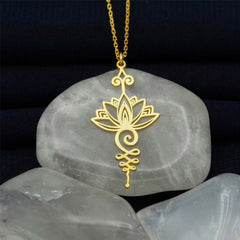 Lotus Luck Wealth Titanium Necklace – gold lotus unalome pendant on chain over pale stones, wealth