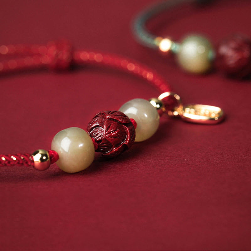 Hetian Jade Cinnabar Lotus Bracelet – Macro close-up of carved cinnabar lotus bead on red cord, bead detail