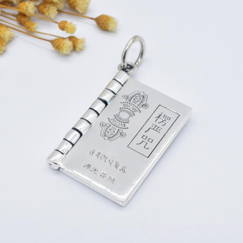 Sterling Silver Heart Sutra Pendant – Three sutra book pendants on wood surface, spiritual