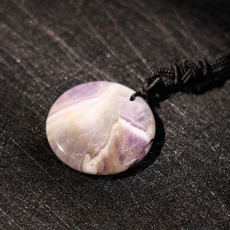 Yin Yang Crystal Necklace – Polished amethyst pendant with purple and gold banding on black cord, natural crystalline mineral
