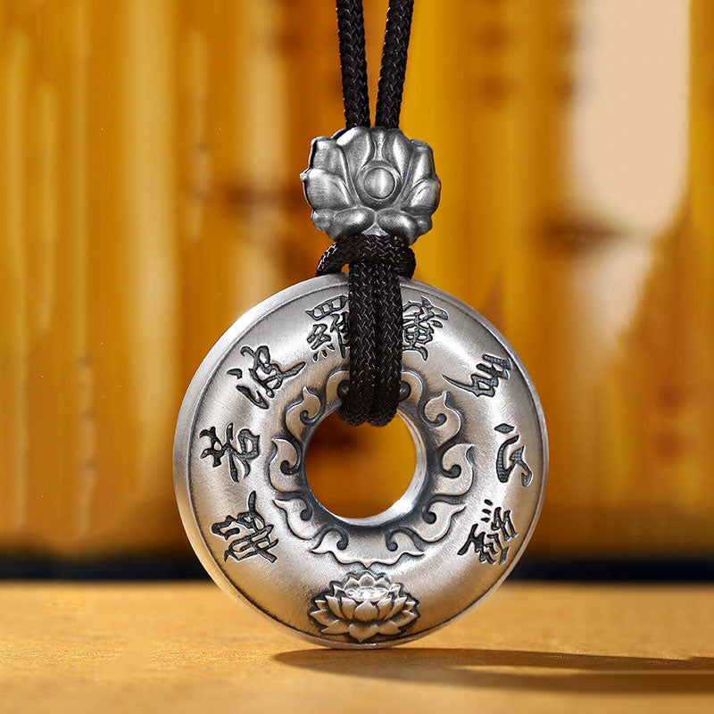 Silver Heart Sutra Pendant – oxidized bi-disc with mantra and lotus on black braided cord, spiritual amulet
