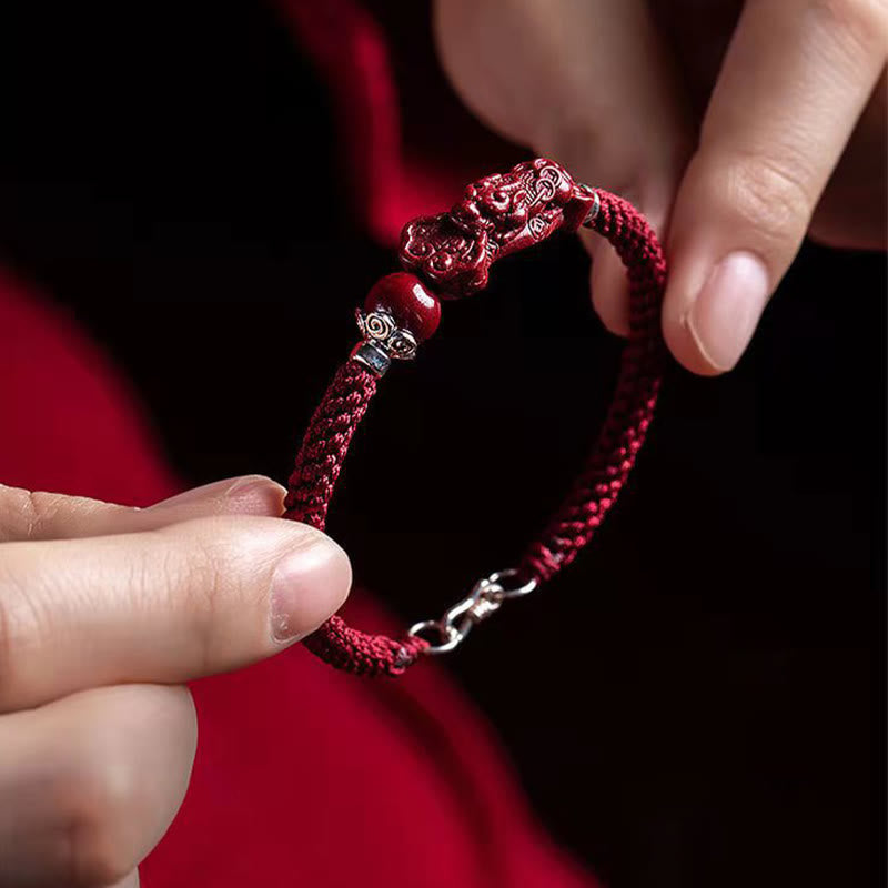Handcrafted PiXiu Cinnabar Wealth Luck Braided Bracelet – hands holding bracelet with red fabric, handmade gift