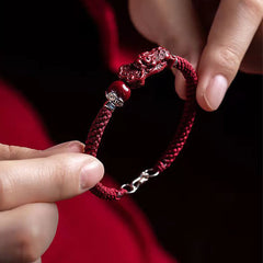Handcrafted PiXiu Cinnabar Wealth Luck Braided Bracelet – hands holding bracelet with red fabric, handmade gift