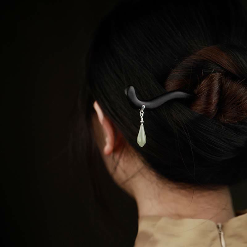 Back view of elegant updo hairstyle secured with ebony wood hairpin and dangling Hetian jade