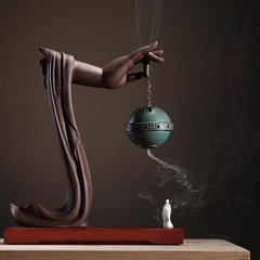 Tibetan Lotus Ceramic Incense Burner – full sculptural view with Buddha hand holding chain on dark wood, Serene