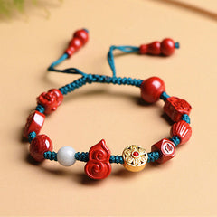 Cinnabar Laughing Buddha Bracelet – worn on wrist with fingers visible, adjustable string closure detail