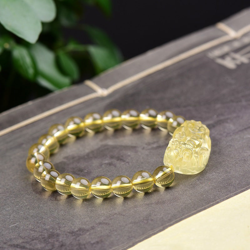 Citrine PiXiu Wealth Bracelet – front view with PiXiu facing right, round yellow beads on dark surface, wealth feng shui bracelet