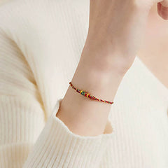 Koi Fish Wealth Bracelet – Angled view of braided red cord with gold koi pendant, lucky bracelet