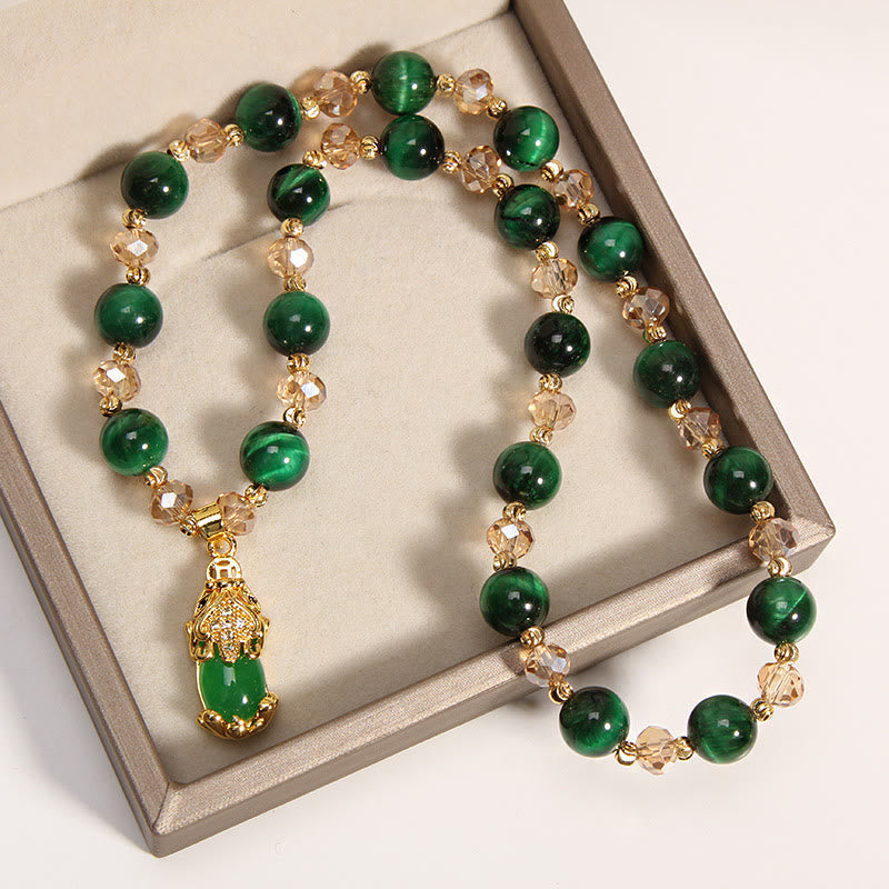 Tiger Eye Pixiu Fox Money Bag Bracelet - double-strand emerald green tiger eye Pixiu bracelet close-up, gold Pixiu charm with green stone inlay and crystal accents, champagne crystal spacer beads on display