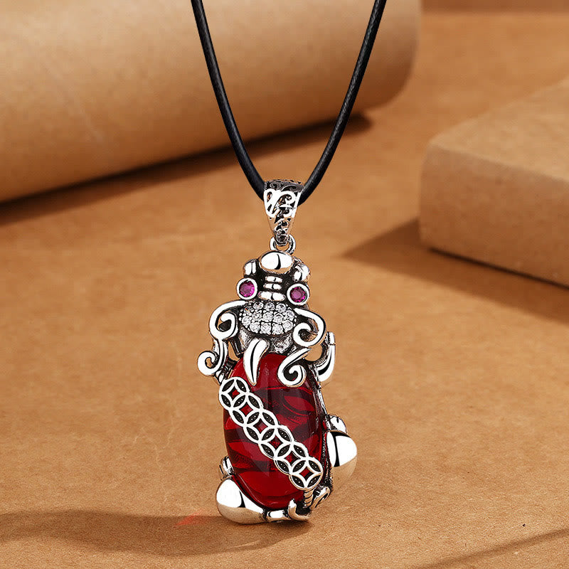 Garnet PiXiu Necklace – PiXiu pendant on black leather cord against brown craft paper, men's necklace
