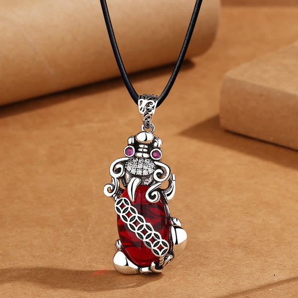 Garnet PiXiu Necklace – PiXiu pendant on black leather cord against brown craft paper, men's necklace