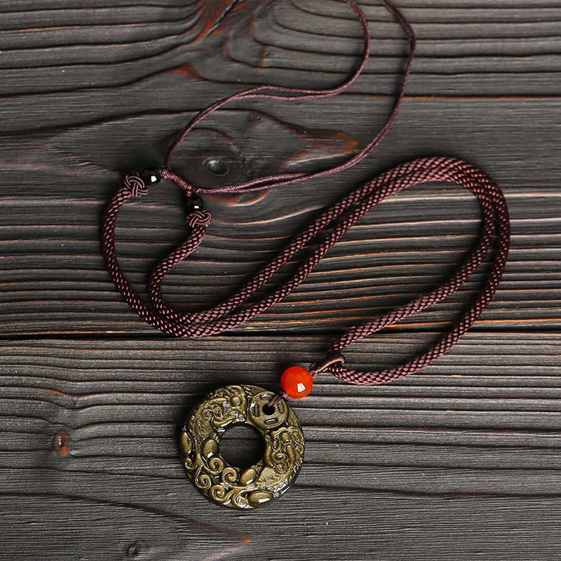 Peace Buckle PiXiu Necklace – Full necklace with purple rope and gold sheen obsidian disc on dark wood, fortune accessory