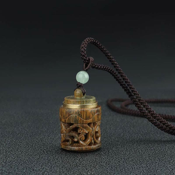 Om Mani Padme Hum Necklace – Cylindrical carved wood pendant with scroll openwork, brass rim accents, jade bead