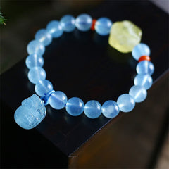 Aquamarine PiXiu Bracelet – Light blue beads with blue PiXiu charm, red spacers, yellow accent, black stand