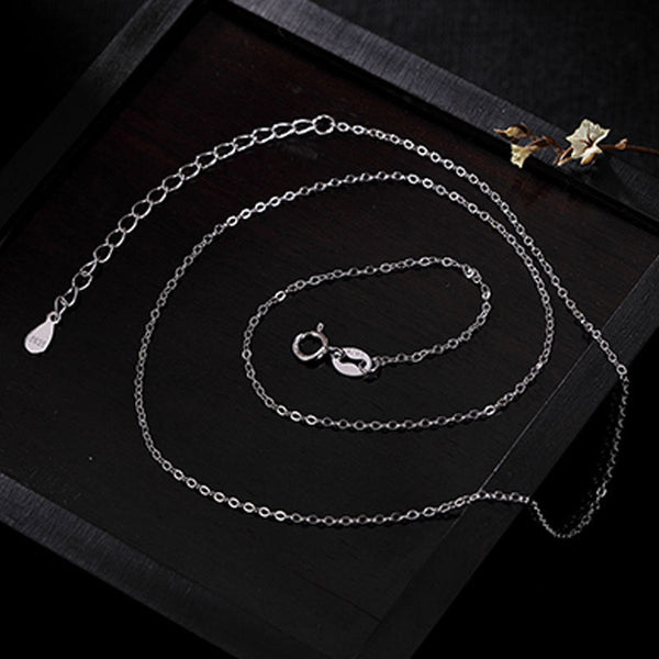 Zen Cairn Crystal Pendant – silver chain with extender laid flat on wooden tray, cable necklace