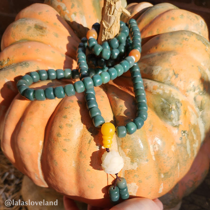 Lotus Cyan Bodhi Seed Bracelet - teal mala draped on heirloom pumpkin with yellow guru bead, outdoor autumn styling
