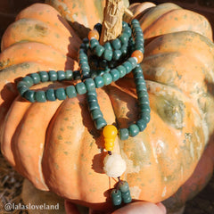 Lotus Cyan Bodhi Seed Bracelet - teal mala draped on heirloom pumpkin with yellow guru bead, outdoor autumn styling