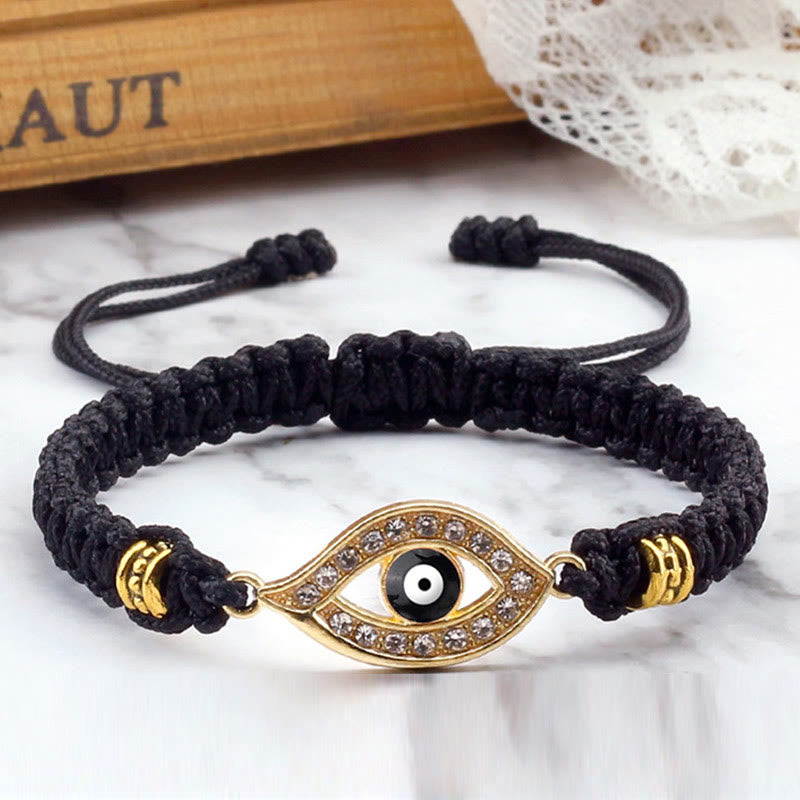 Black cord evil eye bracelet with gold pave crystal charm on marble with lace styling