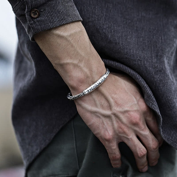 Viking twisted braided copper balance bracelet with runic Elder Futhark inscription twisted rope borders and oxidized silver finish worn with corduroy shirt