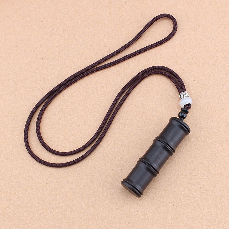 Ebony Wood Bamboo Prayer Box Necklace – Dark bamboo pendant necklace with white and silver accent beads on dark cord, beige textured background