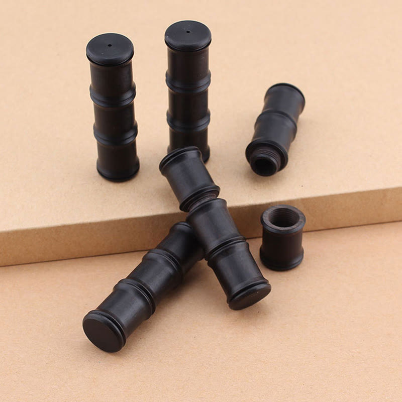 Ebony Wood Bamboo Prayer Box Necklace – Six matte black bamboo-segment cylinders with hollow interiors on two-tiered tan display surface, batch production