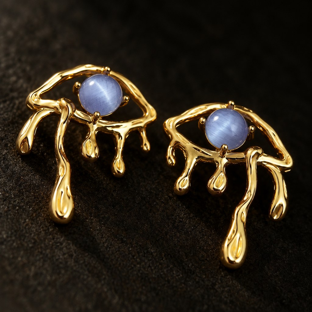 Gold Blue Cat's Eye Drip Earrings - Close-up of the blue glass cat's eye stone in the gold frame, jewelry detail