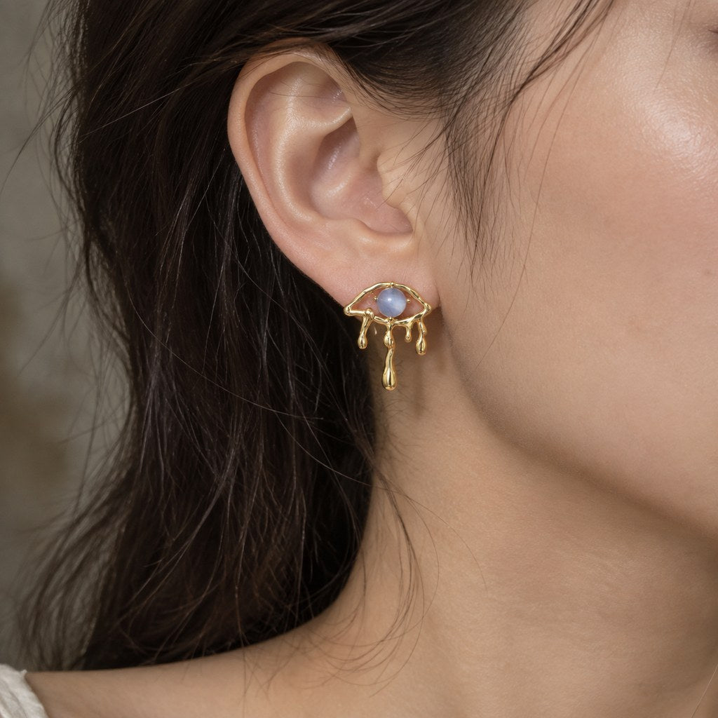 Gold Blue Cat's Eye Drip Earrings - Close-up worn on the ear showing the blue cat's eye and gold frame, stud earring